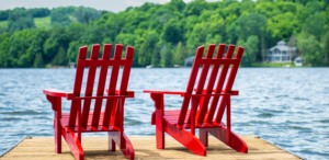 Red Muskoka Chairs on Dock at Lake